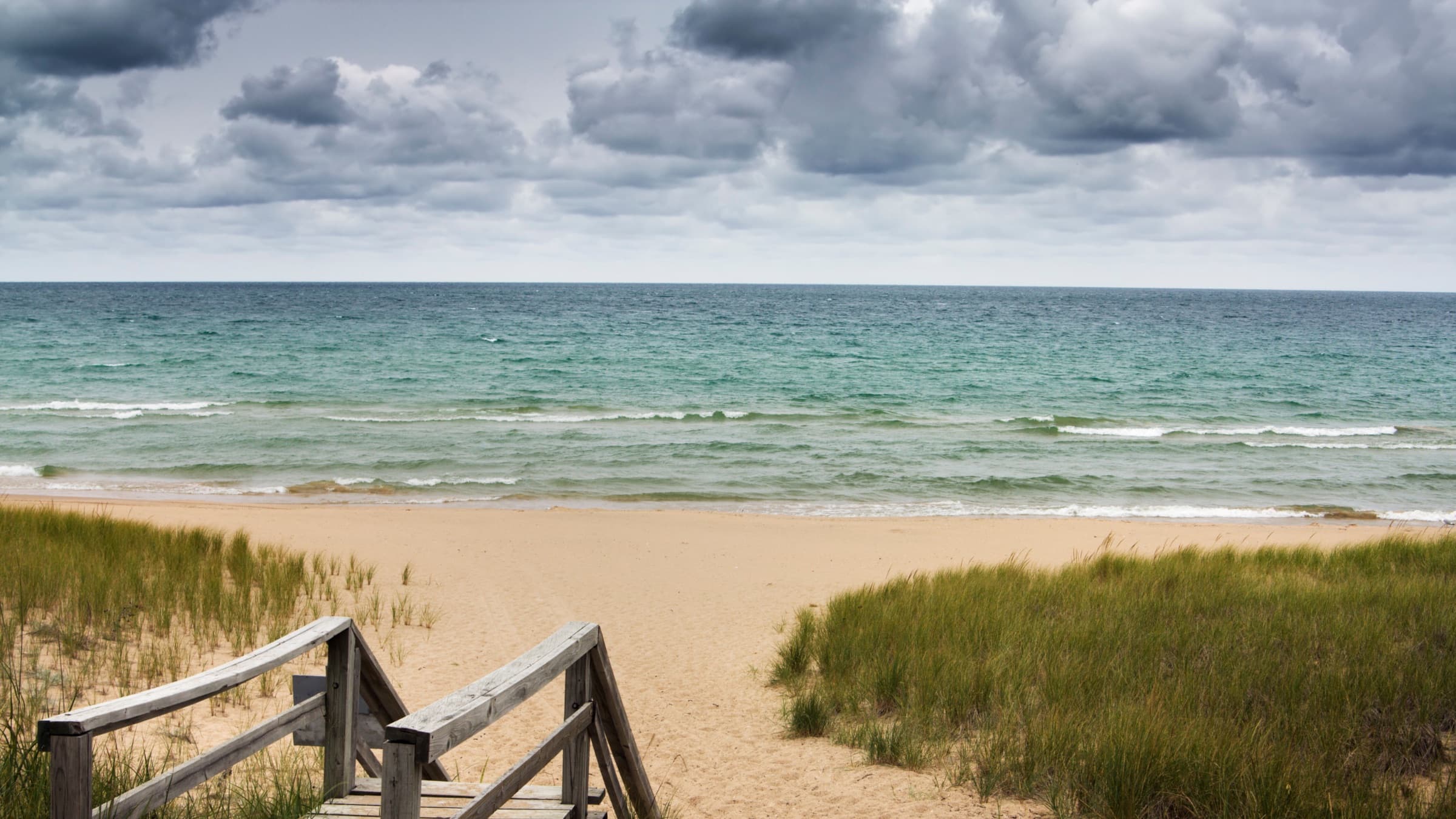 A wooden walkway leading onto a Lake Michigan beach